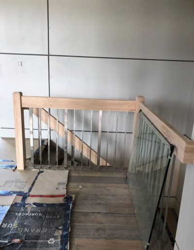 Custom wood and glass railing landing in a Simcoe County home