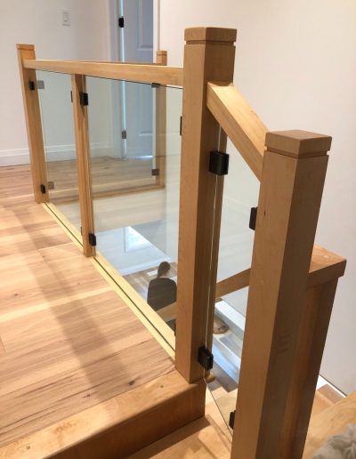 Custom wood and glass stair guardrail with solid wood posts in Simcoe County