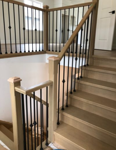 Custom wood staircase with black iron balusters installed in Wasaga Beach