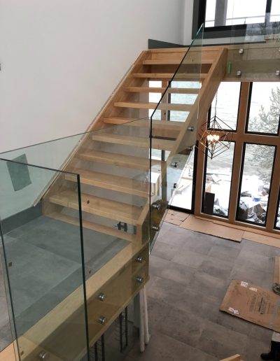 Custom wood staircase with glass railing in a modern Simcoe County home