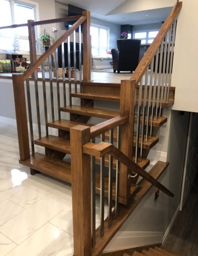 Luxury custom multi-level wood staircase with iron spindles in Simcoe County