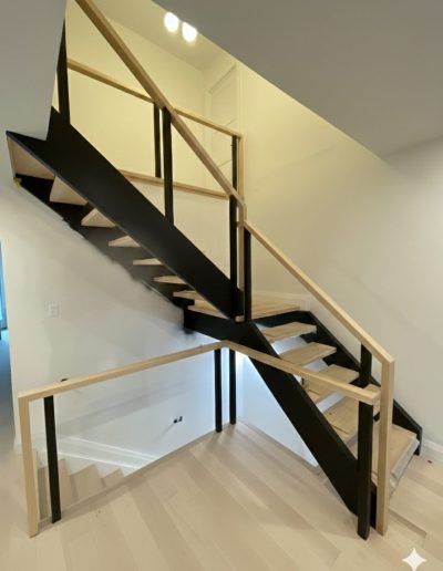 Custom modern mono-stringer staircase with black metal frame and natural wood treads in a Wasaga Beach home.